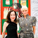Two women standing in front or on colorful prints.