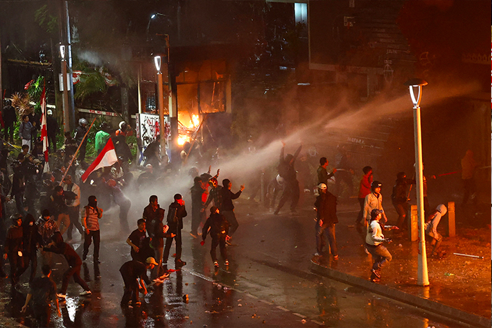 Protesters react during protests outside Jakarta police headquarters