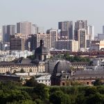 A museum located between trees and skyscrapers.