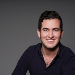 Artnews senior editor Maximilíano Durón's headshot. He was smiling and wearing a black shirt.