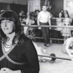 A woman standing next to a boxing team.