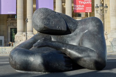 There is a sculpture of a man holding a globe in the square.