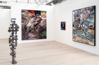 A fair booth with an abstract sculpture and a painting of a man on a horse.