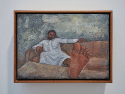A painting of a man in a long white garment reclining on a couch with one foot on a table.