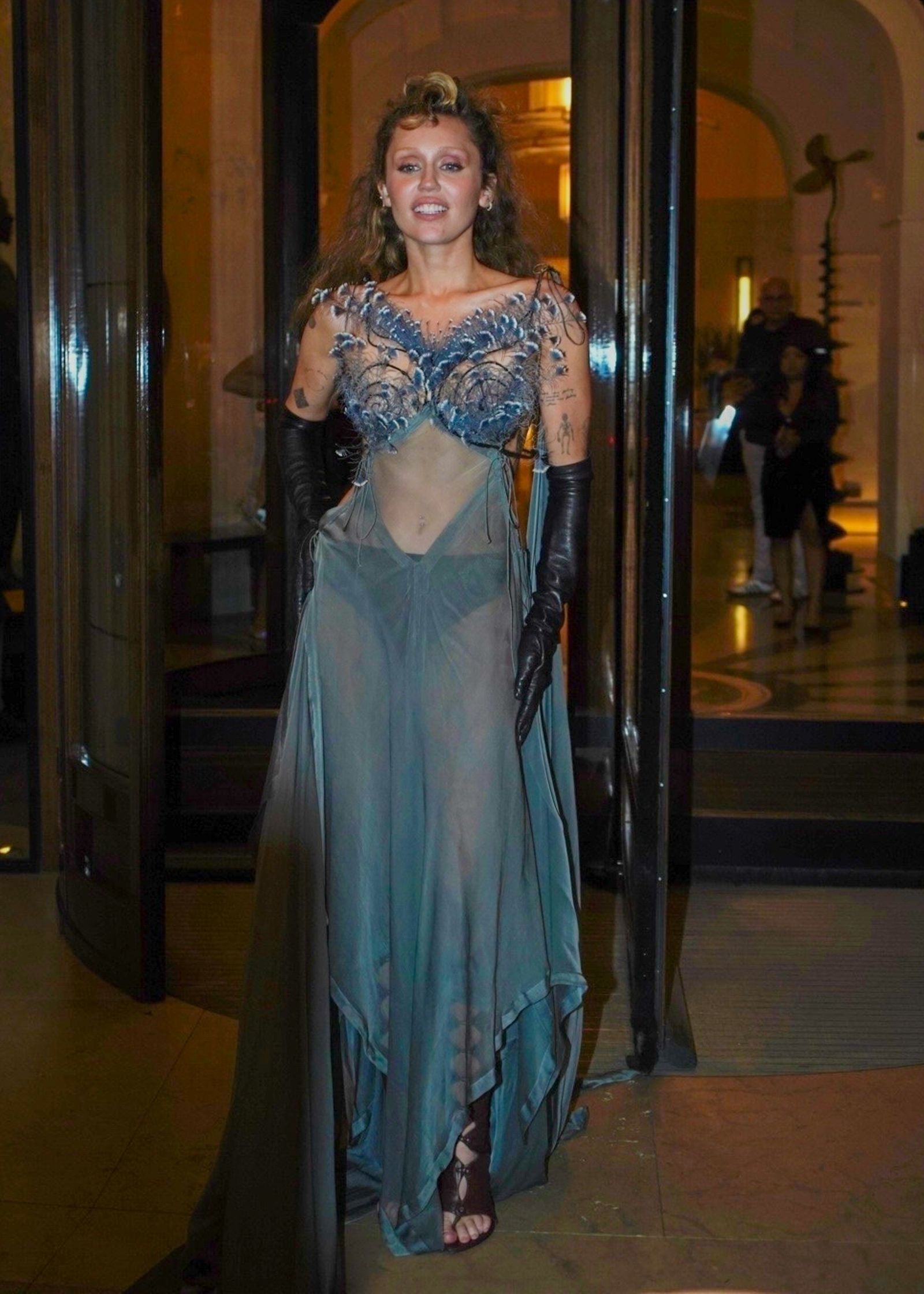 Miley Cyrus greets fans outside Paris hotel in sheer gown