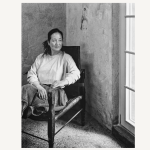 Portrait of a woman sitting in a chair looking out the window.