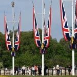 Tourists outside Buckingham Palace in St. James's Park, London, UK, 2025.