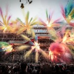 A swarm of colorful fireworks explodes from the museum's exterior wall.