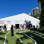 People walked around the courtyard in front of a tent that read 