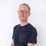 Portrait of a smiling white man wearing glasses.