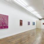 The gallery walls are covered with still life paintings.