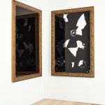 A work of art with two panels, each with mirror and black area, installed in the corner of the room.