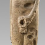 An Egyptian statue missing its head and penis.