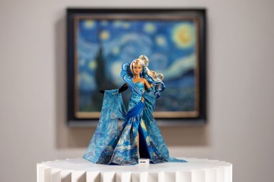 A Barbie doll's evening-style dress stands in front of the painting, which is out of place.