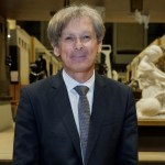 A man in a suit stands in the exhibition hall.