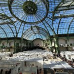 A glass-domed building with fair stalls.