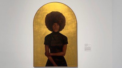 A painting of a Black woman with a large afro surrounded by gold leafing.