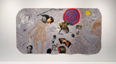 A painting of a three-headed figure next to a target and various bits of text.