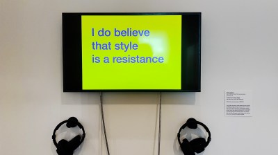 A screen with a blue text on a yellow background reading 'I do believe that style is a resistance.'
