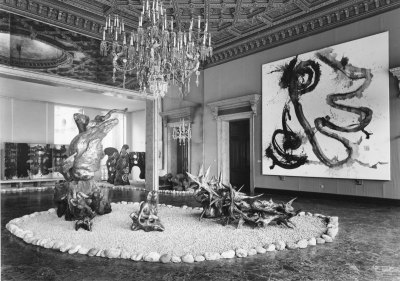 Archival image of paintings and sculptures in a palace in Venice. The ceramics are installed in a rock garden-like setting.