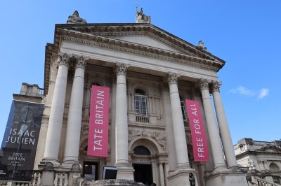 Column-shaped building facade, hung with pink banners.