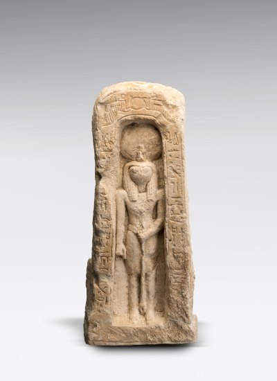 A small Egyptian artifact is embedded in an alcove, surrounded by hieroglyphics. 