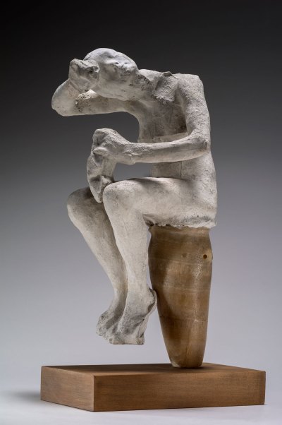 Plaster sculpture of a woman sitting on an ancient Egyptian vase.