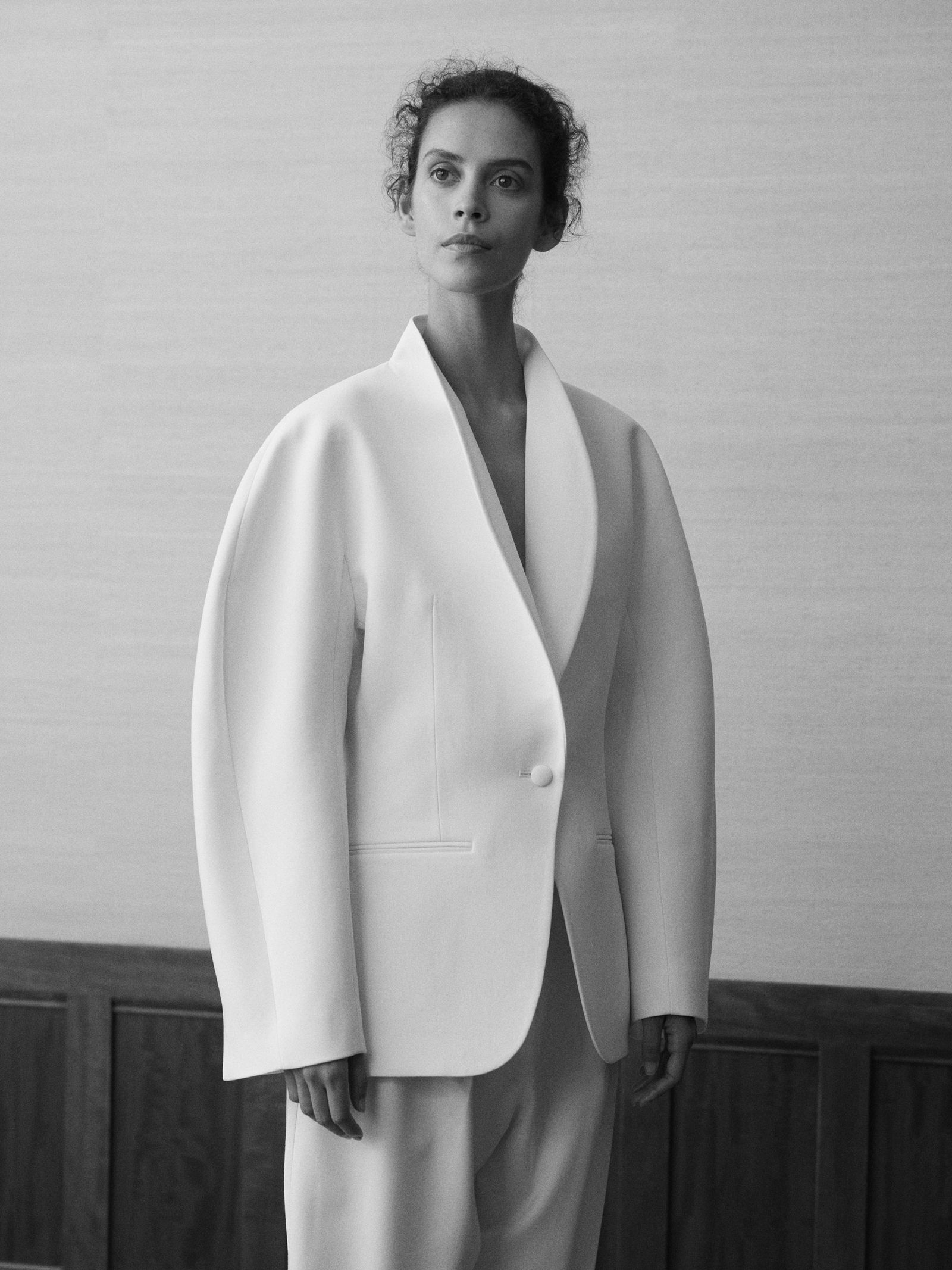 Image may contain clothing, formal suits, tuxedos, faces, heads, people, photography, portraits, coats, adults and jackets