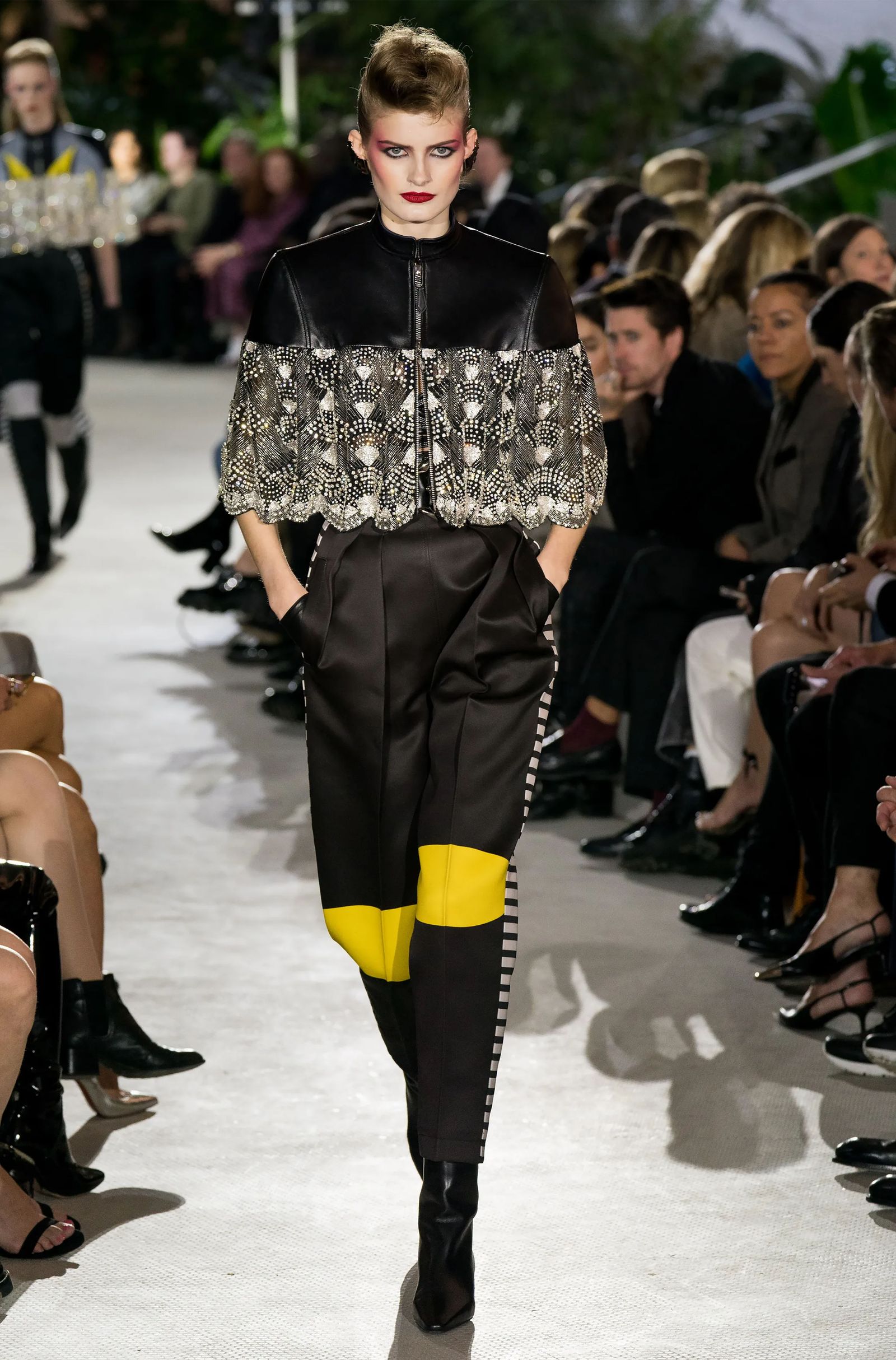 Image may contain adult clothing, sleeves, fashion footwear, high heels, shoes, pants and runways