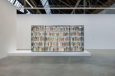 A bookshelf filled with books on a plinth.