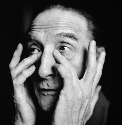 A man pressing one finger to the corner of each of his eyes.