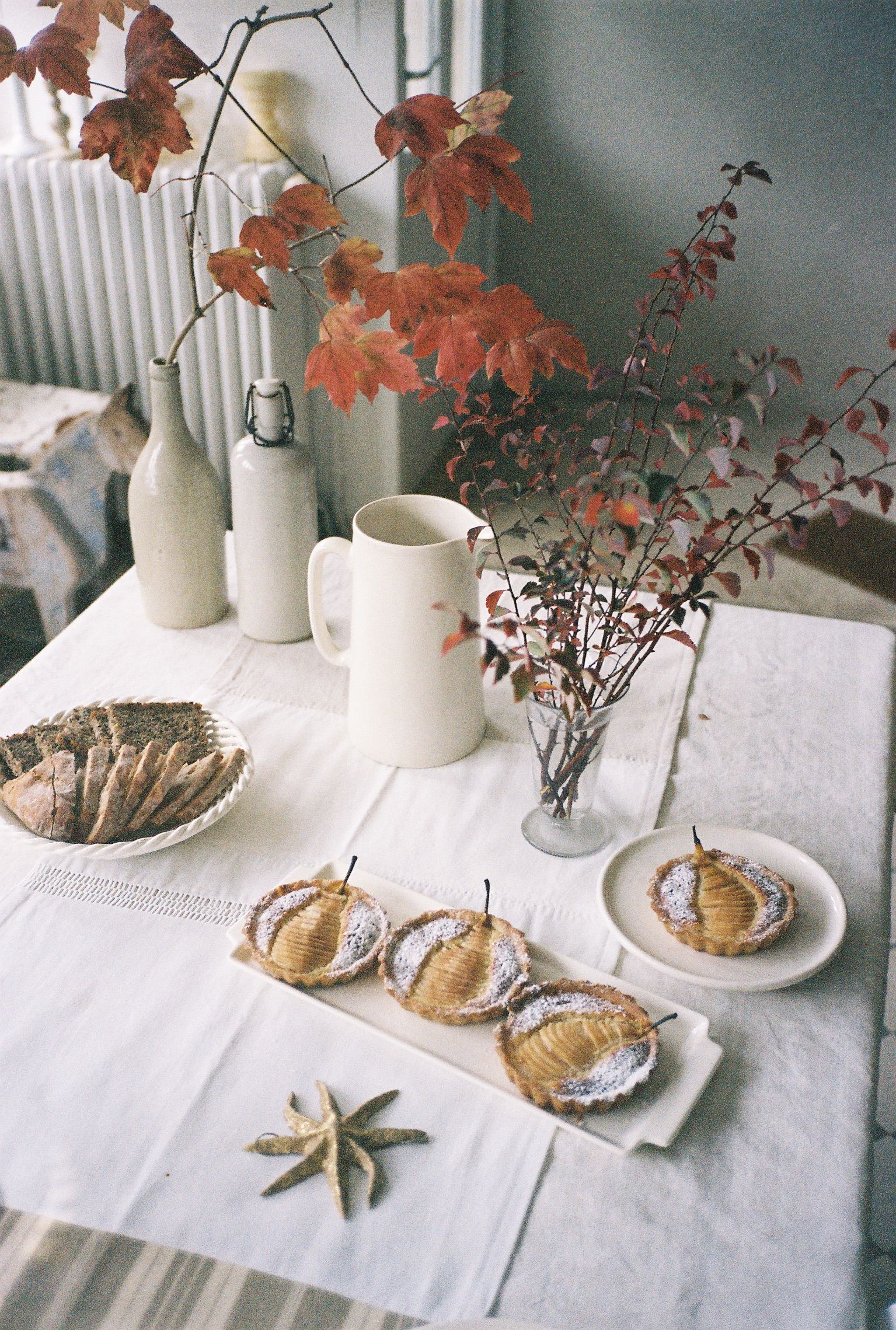 Image may contain leafy plants, furniture, tables, tabletops, dining tables, cups, potted plants, plates, art and china