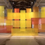 A collection of unevenly hung translucent orange, yellow and red fabrics.