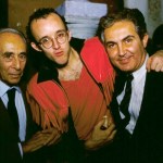 Two gentlemen in suits and a young man wearing red glasses.