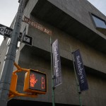 Stop walking signal near block concrete building.