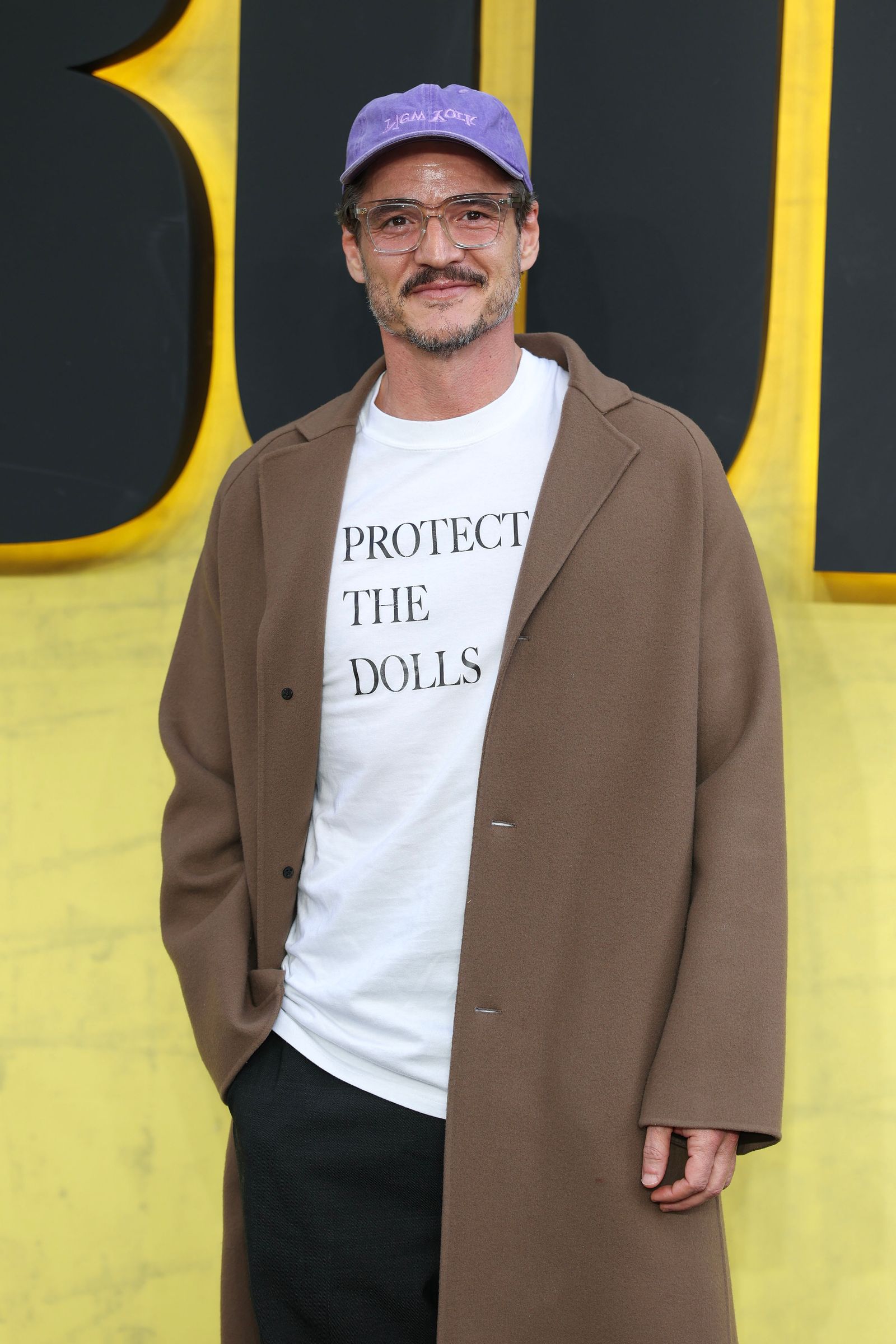 Image may contain Pedro Pascal clothing coat jacket adult coat blazer hat face and head