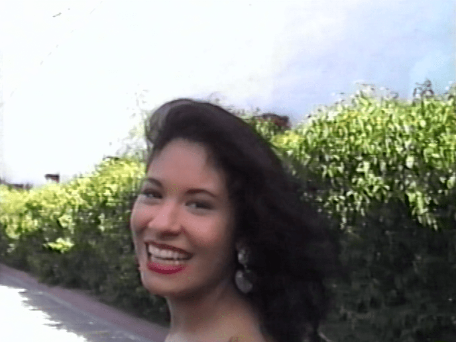 Image may contain Selena Quintanilla head, face, happy smile, body, part, neck photography, portrait and laugh