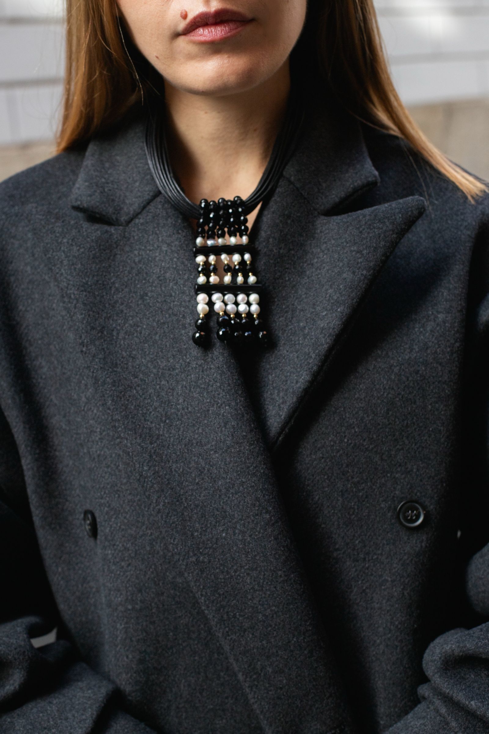 Image may contain clothing, outerwear, accessories, jackets, jewelry, necklaces, pendants and blazers