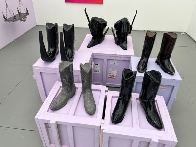 There are several pairs of shoes on a lavender shipping box.