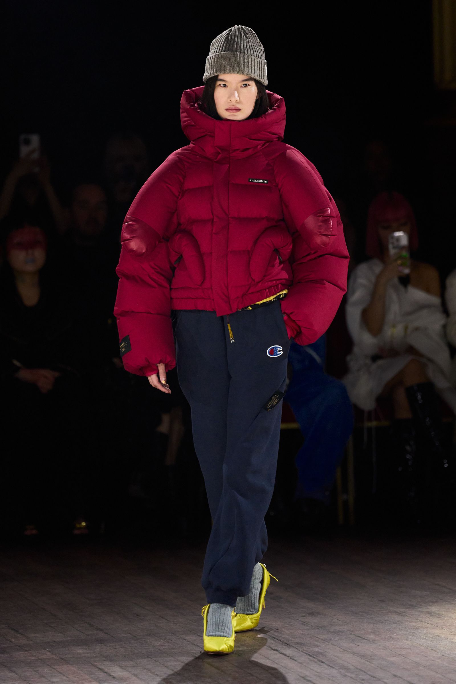 Image may contain clothing, coats, hats, adult jackets, gloves, fashion footwear, shoes, electronics and mobile phones