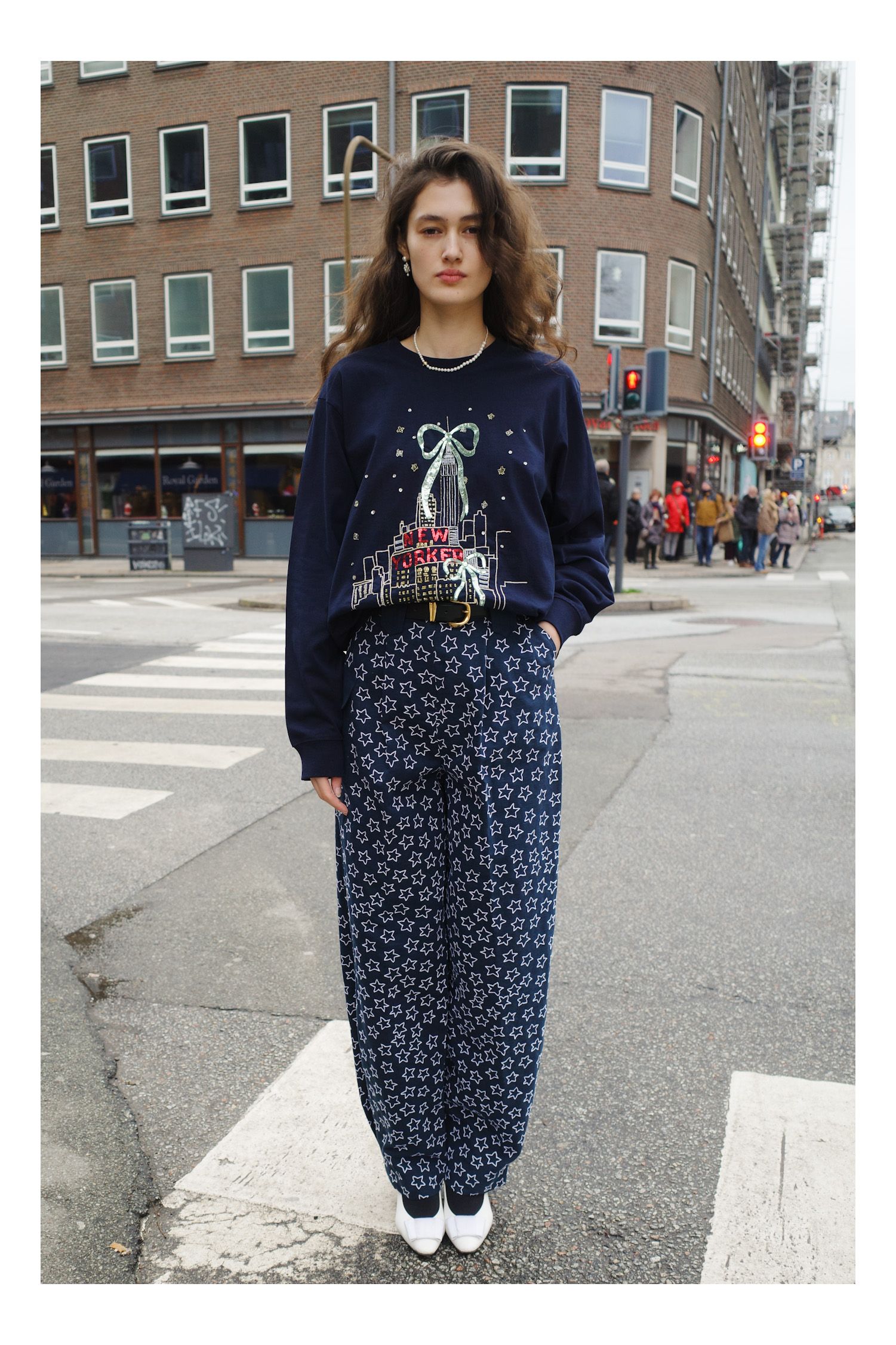 Image may contain clothing, pants, long sleeves, sleeves, standing, car, vehicle, adult and city