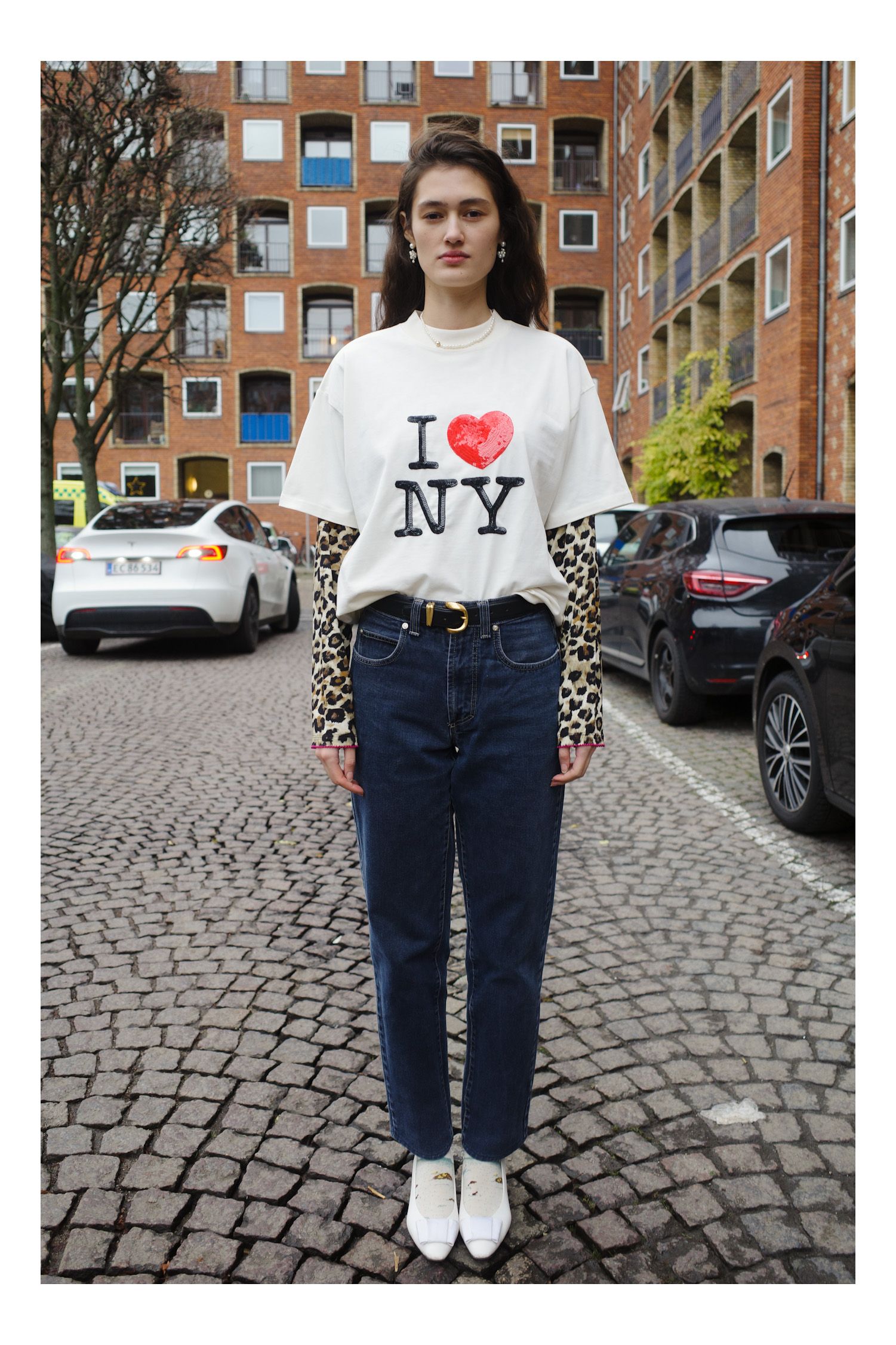 Image may contain clothing, pants, t-shirt, jeans, teen city standing, road, street, city face and head