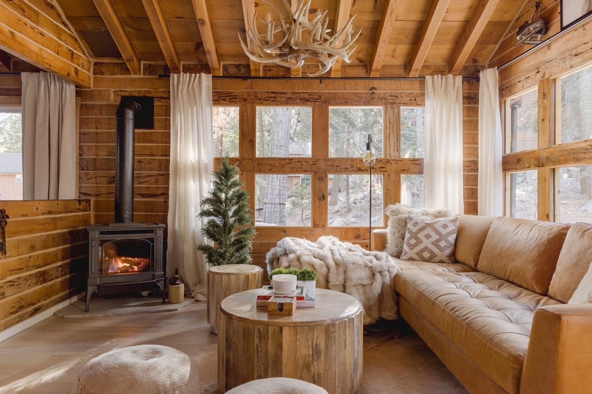 Image may contain wooden interiors, coffee tables, furniture, tables, chandeliers, lamps, plants and trees