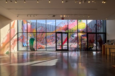The glass facade is covered with colorful abstract forms.