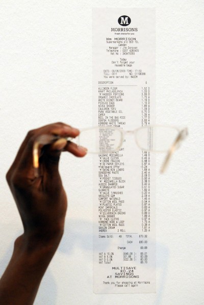 A man holds a pair of glasses on a receipt.