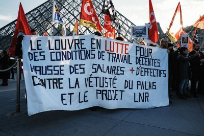 Museum staff hold banners and union flags outside the entrance to the Louvre at the world-famous museum on December 15, 2025 in Paris, France, as workers voted to go on strike to protest deteriorating working conditions and declining visitor experience at the world-famous museum. (Photo: Jerome Gilles/NurPhoto via Getty Images)