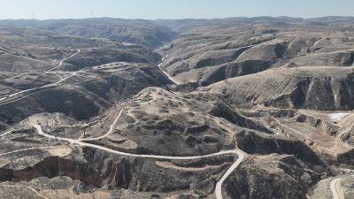 aerial view of brown mountains with roads snaking through
