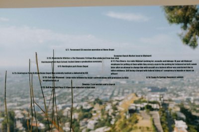An installation in which dates and details of people abducted by ICE are superimposed on a window with a view of Los Angeles out of focus in the background.