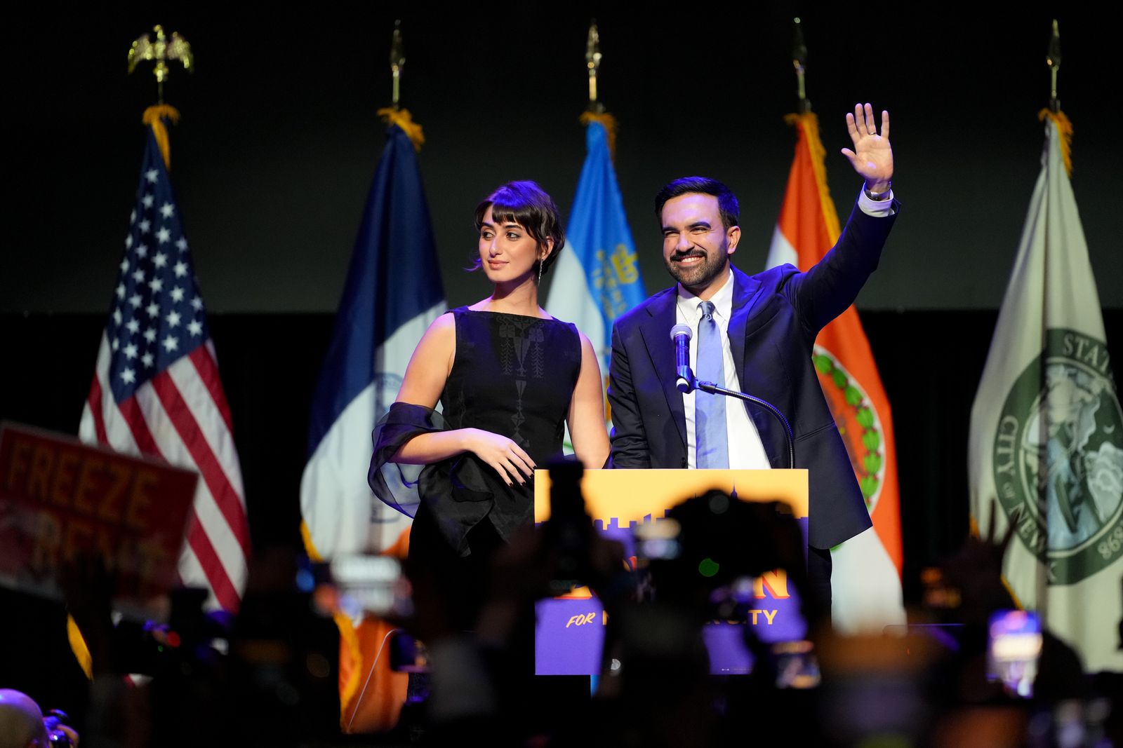 Image may contain people, lights, blazer, coat, adult purple formal suit and crowd