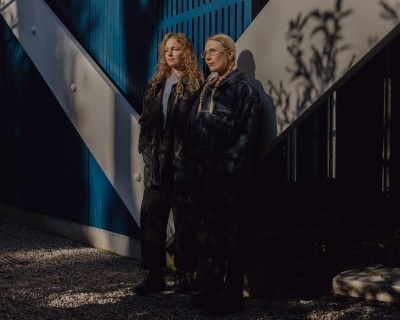 Two white woman standing in front of a gate.